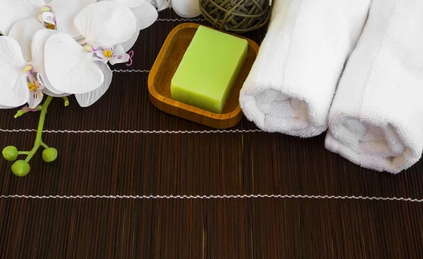 Спа-натюрморт с орхидеей, натуральным мылом и полотенцами — стоковое фото