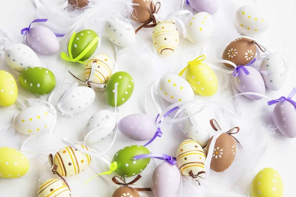 Velikonoční vejce tečkovaný, malované, zdobené peřím na bílé ba — Stock fotografie