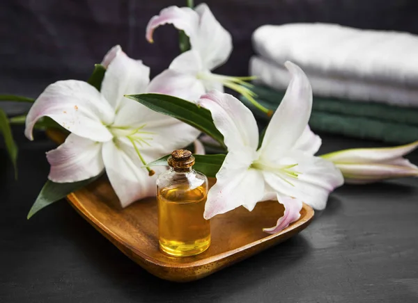 Aromaterapia Spa, aceite de baño con flores de lirio y toallas —  Fotos de Stock
