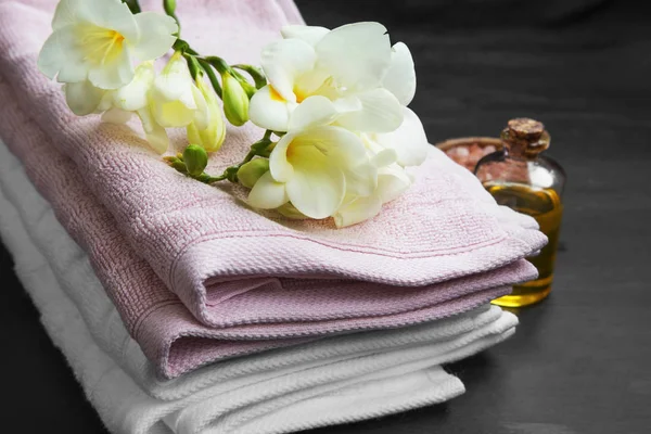 Lázně. Bílé květy na vrcholu měkké ručníky s koupelový olej a sůl — Stock fotografie