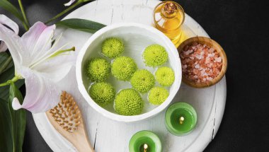 Rahatlatıcı spa ayarıyla su kabı ve yeşil çiçekler, yağ, tuz