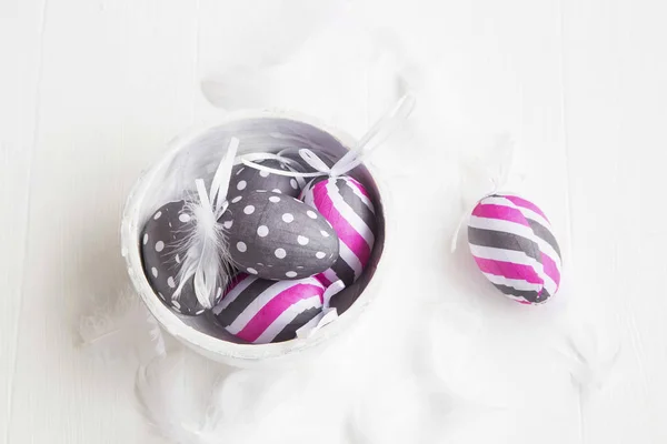 Ovos de Páscoa decorados e penas na tigela branca — Fotografia de Stock