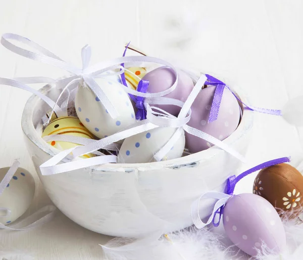 Beyaz ahşap kase tüyler Paskalya yumurtaları süslenmiş — Stok fotoğraf