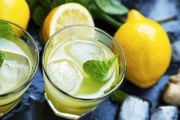 Fresh mojitos cocktails with lemons, fresh mint, ice cubes and s — Stock Photo, Image