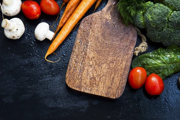 Tablero de madera con marco de verduras orgánicas frescas, zanahorias, hongos — Foto de Stock