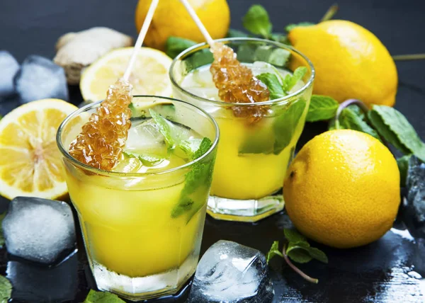 Bebidas frescas de limonada vasos con hojas de menta, limones, cubitos de hielo — Foto de Stock