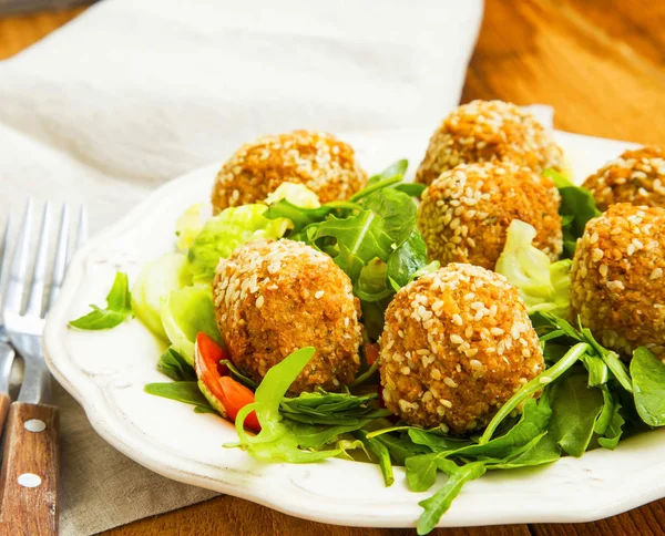 Falafel.Chickpeas ballen met sesam en groene salade op plaat — Stockfoto