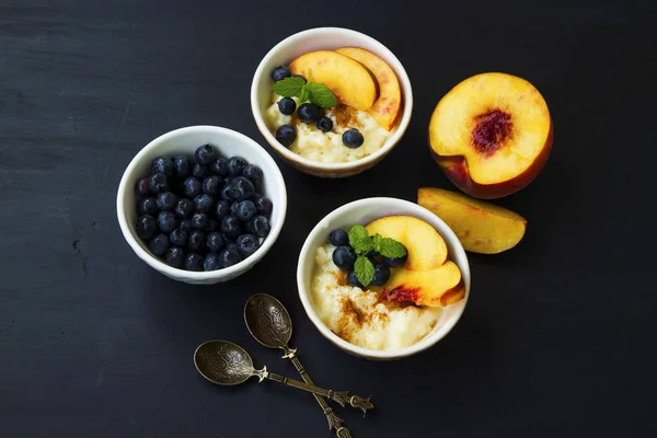 Pudding dessert bowls with peaches and blueberries, mint leaves — Stock Photo, Image