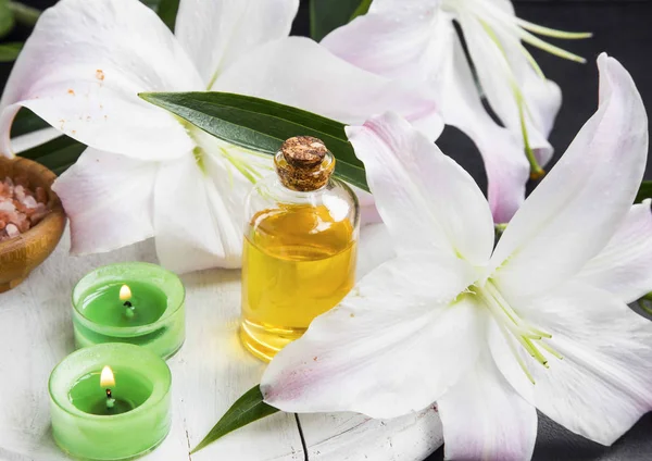 Huile aromatique de fleurs de spa avec lys et bougies parfumantes — Photo