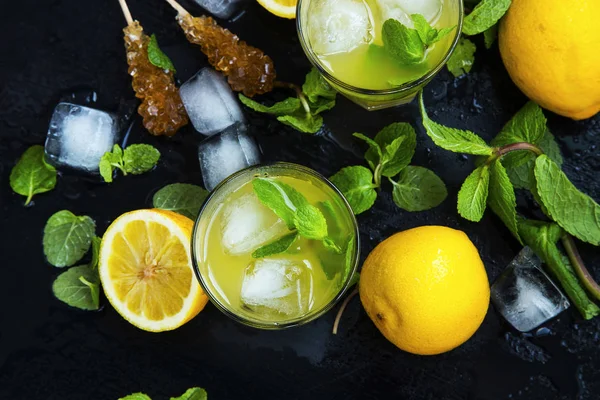 Vista superior de las bebidas de limón y menta con hielo y palitos de azúcar en d — Foto de Stock