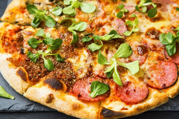 Pizza with salami and green leaves freshly baked, rustic pizza — Stock Photo, Image