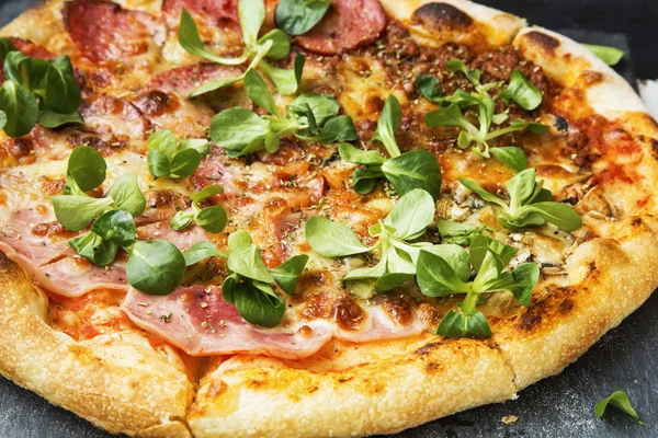 Pizza with salami and green leaves freshly baked, rustic pizza — Stock Photo, Image