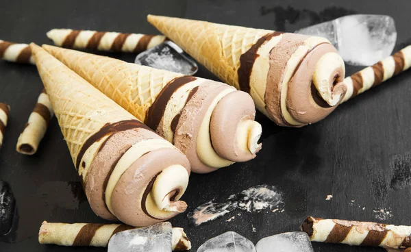 Шоколад и карамельное мороженое спирали в вафельных рожках — стоковое фото