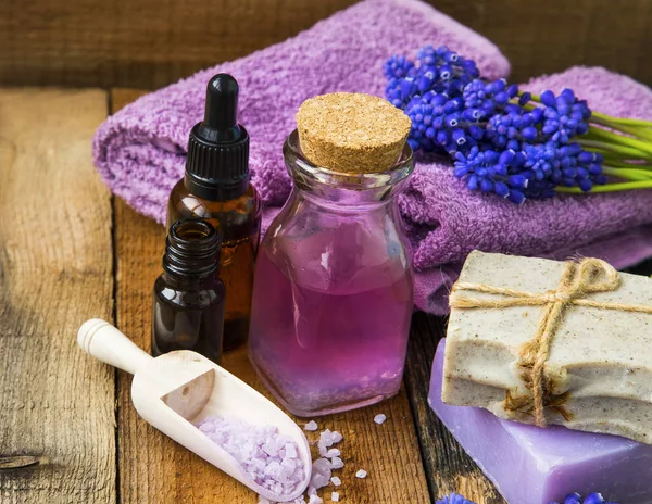 Spa e olio di aromaterapia, asciugamani, fiori viola, sapone, sale da bagno — Foto Stock