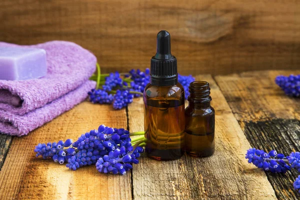 Spa avec bouteilles d'huiles d'aromathérapie et fleurs violettes sur woo — Photo