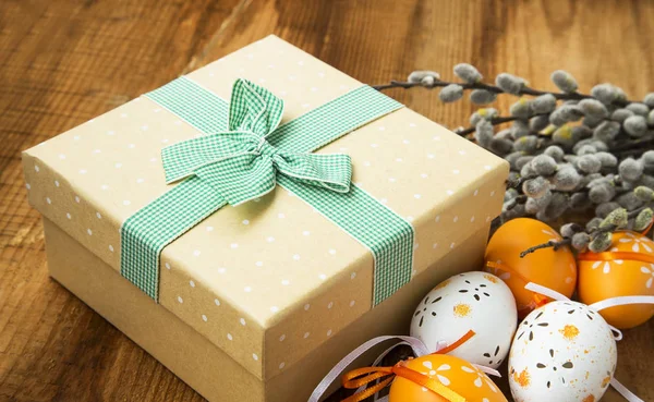 Пасхальное украшение с подарочной коробкой и украшенными пасхальными яйцами — стоковое фото