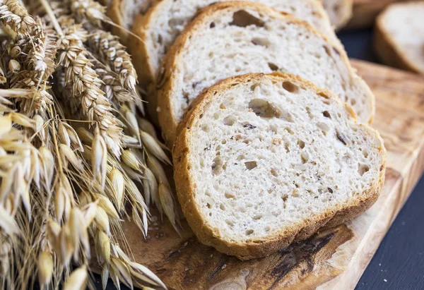 Целый хлеб пшеницы с колосьями и семенами, ломтики хлеба на воу — стоковое фото