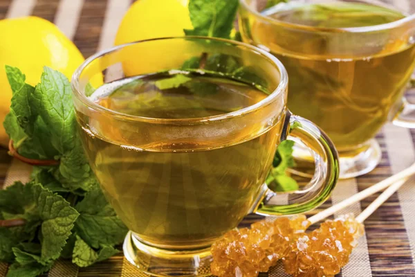 Té de menta y limón en vidrio transparente con hierba de menta y azúcar —  Fotos de Stock