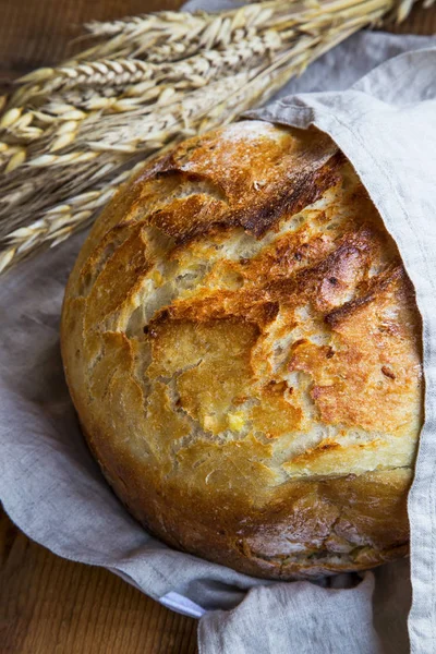 Du pain rustique. Pain rond entier avec croûte dorée en towe de lin — Photo