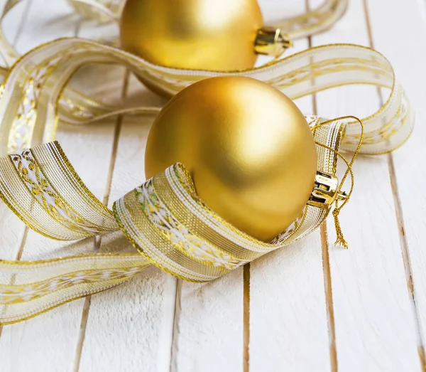 Золотые праздничные рождественские шары украшения с лентой на белом — стоковое фото