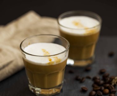 Espresso kahve latte gözlük süt köpüğü ve kahve çekirdekleri ile , 