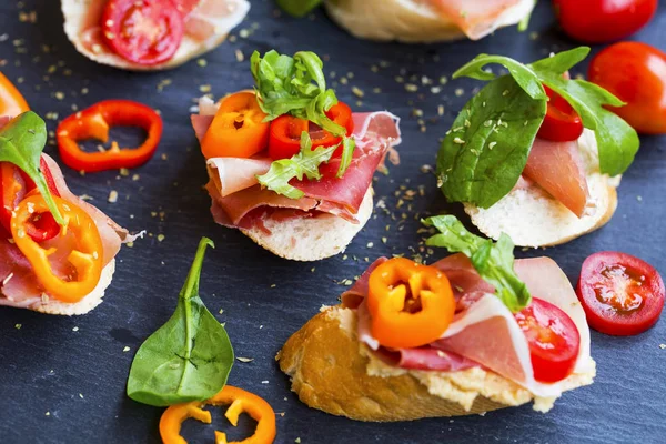 Canapes appetizer dengan ham prosciutto, irisan lada, tomat — Stok Foto
