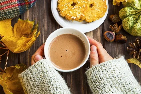 Donna mani in possesso di tazza di cioccolata calda con biscotti, autunno c — Foto Stock