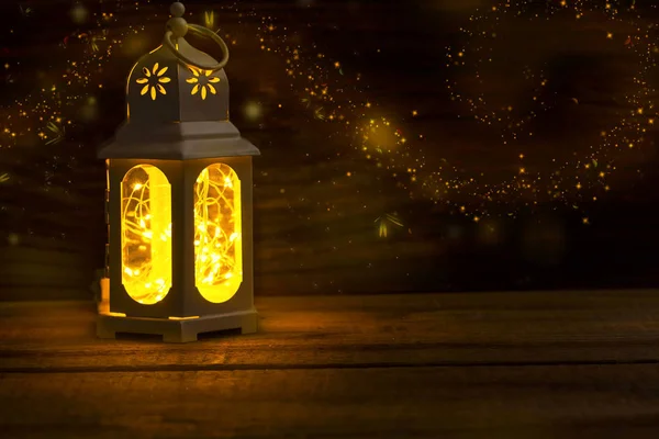 Magic lantern with glowing lights and fireflies on old wooden ba — Stock Photo, Image