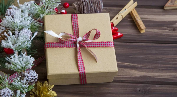 Świąteczny prezent z wstążki i Świąteczne ozdoby na drewniane ba — Zdjęcie stockowe