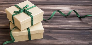 Ahşap üzerinde yeşil kurdele ile süslenmiş şenlikli şık hediye kutuları 