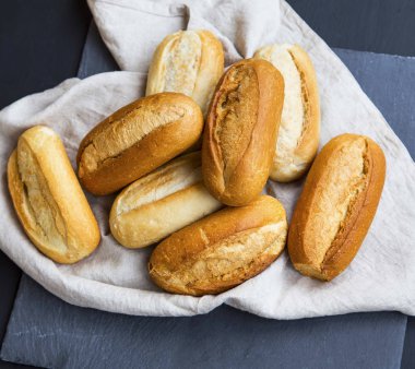 Fırından yeni çıkmış ekmek buns keten bir havlu, tüm ekmek buns yığın üzerinde