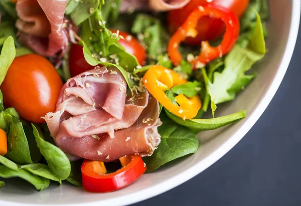 Fresh prosciutto ham and vegetables salad closeup with spinach , — Stock Photo, Image
