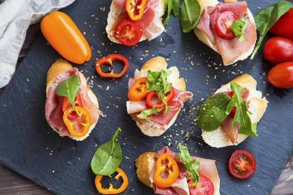 Bruschettas atau pengaturan crostini dengan ham prosciutto, hijau s — Stok Foto