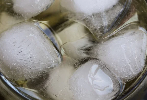 Cubos de gelo closeup em um refrigerante ou líquido — Fotografia de Stock