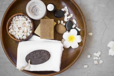 Spa Ürünleri içinde mum, havlu, frangipani çiçek, tuz ve doğal sabun ile ahşap tepsi. Üstten Görünüm