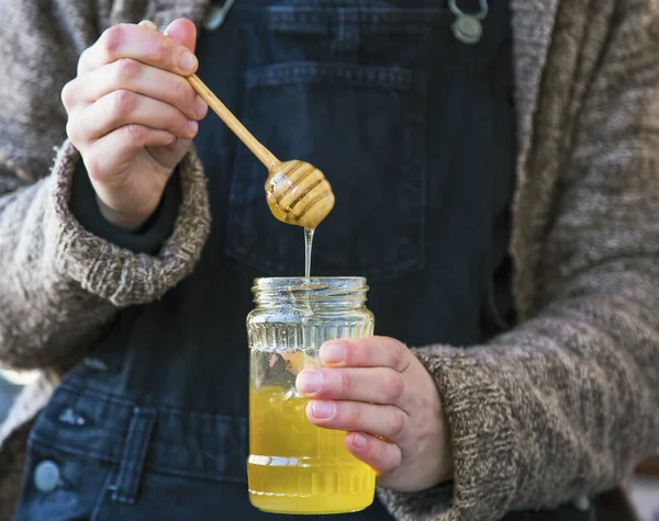 生の有機蜂蜜瓶を保持女性の手 — ストック写真
