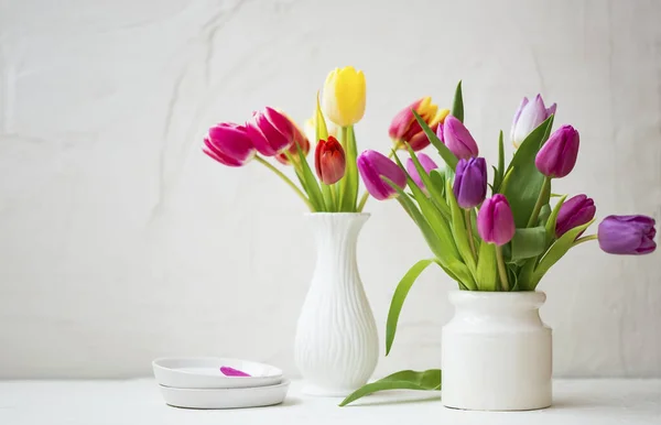 美丽的白色花瓶中的春天郁金香花束 图库图片