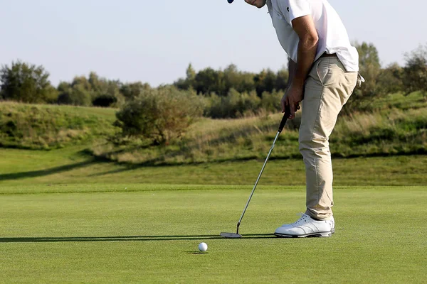 Um jogador de golfe em um verde Fotos De Bancos De Imagens