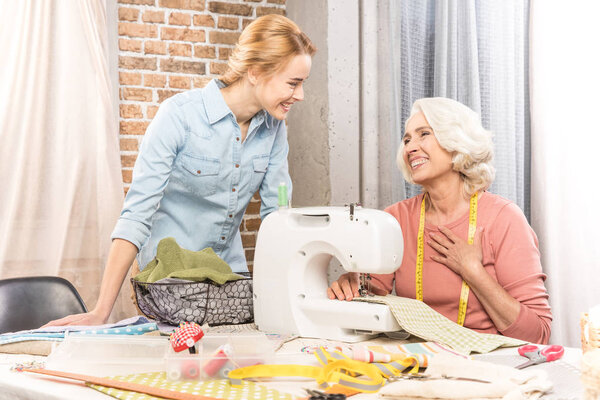 Senior woman and girl sewing 