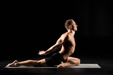 Adam yoga pozisyonunda oturuyor.