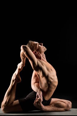 Adam yoga pozisyonunda oturuyor.