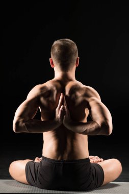 Adam yoga pozisyonunda oturuyor.