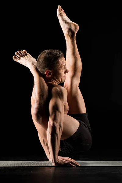 Muž, který stojí v pozici jóga — Stock fotografie