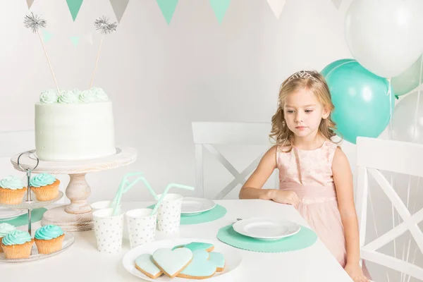 Menina adorável na mesa de aniversário — Fotografia de Stock