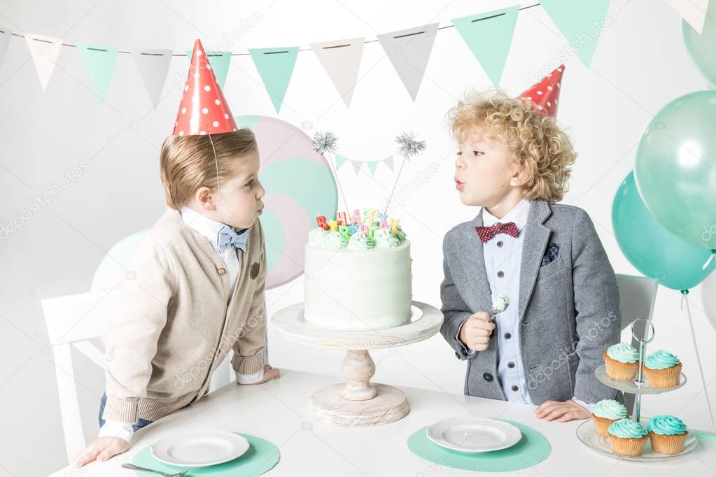 Boys blowing candles on cake