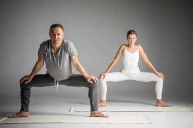 Couple practicing yoga clipart