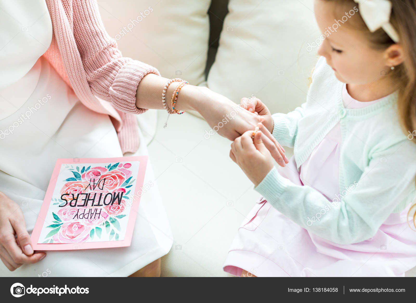 Girl putting jewelry on mother — Stock Photo © OlgaZakrevskaya 138184058