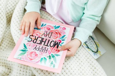 Anneler günü kartı tutan çocuk 