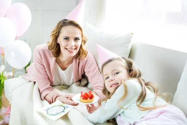 Moeder en dochter met aardbei cake — Stockfoto