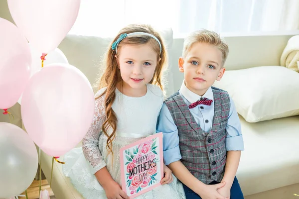 Siblings holding Mothers Day card — Stock Photo, Image